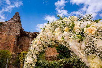 Symbolic wedding ceremony archway of roses, lisianthus and babys breath gypsophilia in Taormina