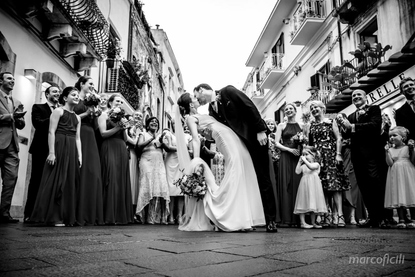 Bride and Groom delight their guests with a romantic kiss on the Corso Umberto in Taormina