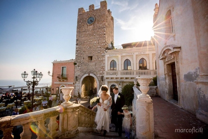 Bride and Groom climb the steps at San Giuseppe Church for a photo by the clock tower in Piazza IX Aprile Taormina