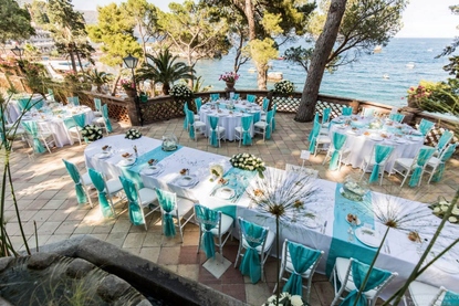 Table runners and chair drops in a blue hue for a wedding reception by the sea at Belmond Villa Sant'Andrea Taormina