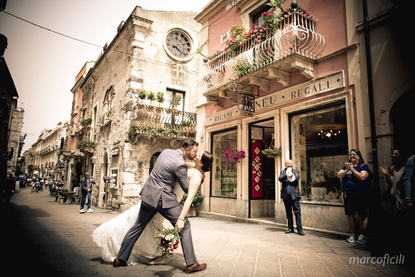 Bride and Groom entertain onlookers with a passionate kiss on the Corso Umberto in Taormina