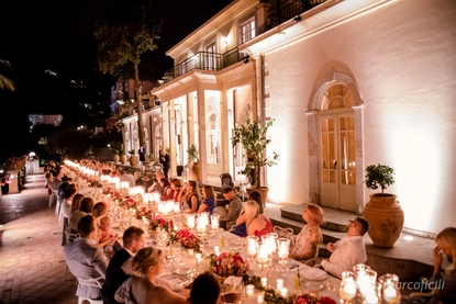Wedding guests enjoying the reception dinner seated at an amazing Imperial table at the Belmond Grand Hotel Timeo