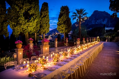Imperial table with floral bouquets on gold pedestals and stemmed vase floating candles at Belmond Grand Hotel Timeo Taormina