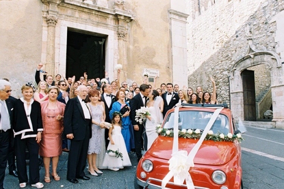 Quirky vintage red Fiat Cinquecento bridal car outside Santa Caterina Church in Taormina