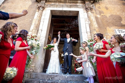 Rice and petals shower the newlyweds outside Santa Caterina Church in Taormina