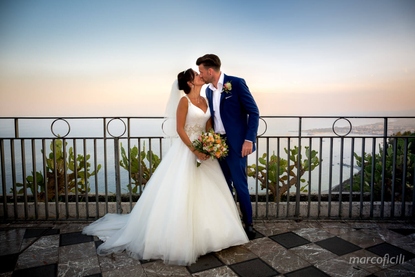 Bride and Groom share a kiss at sunset in Piazza IX Aprile Taormina Corso Umberto